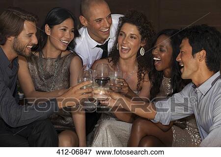 Stock Photo - Friends toasting each other at party. Fotosearch
