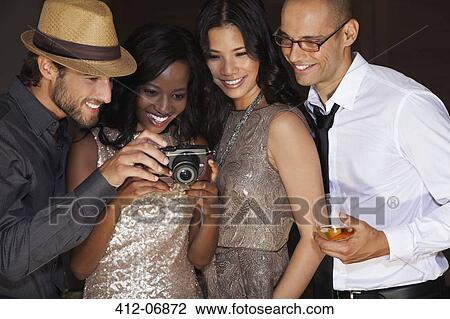 Friends using camera at party View Large Photo Image Stock Image - Friends using camera at party. Fotosearch