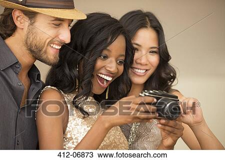 Friends using camera at party View Large Photo Image Stock Image - Friends using camera at party. Fotosearch