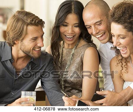 Stock Photo - Friends using cell phones at party. Fotosearch