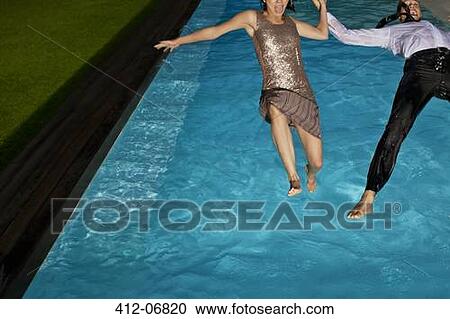 Fully dressed couple jumping into swimming pool View Large Photo Image Stock Image - Fully dressed couple jumping into swimming pool. Fotosearch