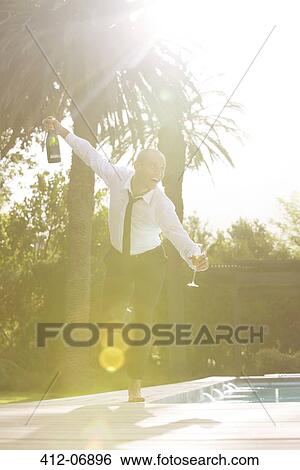 Stock Photograph - Man drinking by swimming pool. Fotosearch