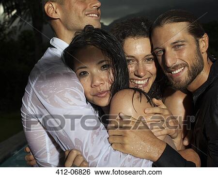 Stock Photograph - Smiling friends hugging outdoors. Fotosearch