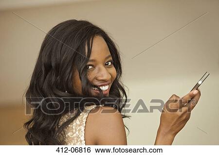 Smiling woman using cell phone View Large Photo Image Stock Photograph - Smiling woman using cell phone. Fotosearch