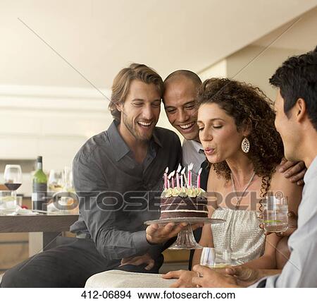 Woman blowing out birthday candles View Large Photo Image Picture - Woman blowing out birthday candles. Fotosearch