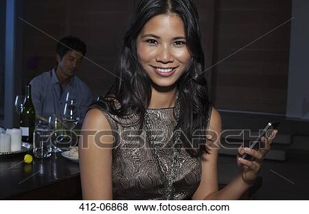 Stock Photo - Woman using cell phone at party. Fotosearch
