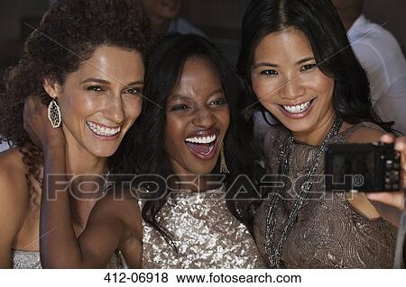 Women in evening gowns taking picture together View Large Photo Image Stock Photo - Women in evening gowns taking picture together. Fotosearch