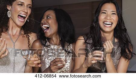 Picture - Women laughing together at party. Fotosearch
