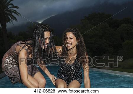Stock Photo - Women playing by swimming pool. Fotosearch