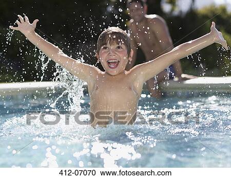 Stock Image - Boy playing in swimming pool. Fotosearch
