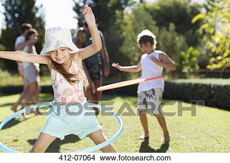 Picture - Children hula hooping in backyard. Fotosearch