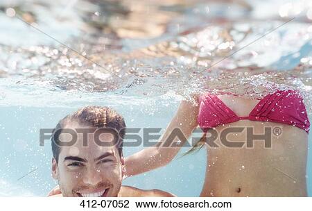 Couple playing in swimming pool View Large Photo Image Stock Image - Couple playing in swimming pool. Fotosearch