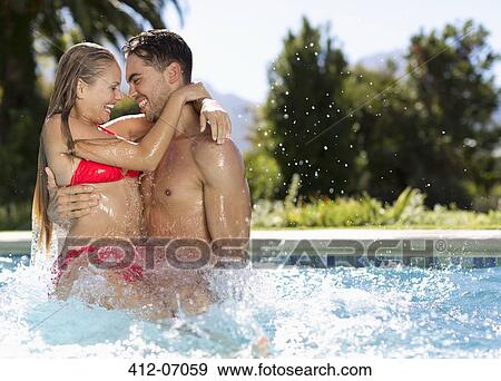 Stock Photo - Couple playing in swimming pool. Fotosearch