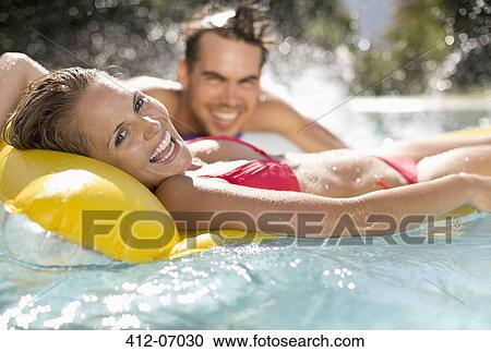 Couple relaxing in swimming pool View Large Photo Image Stock Image - Couple relaxing in swimming pool. Fotosearch