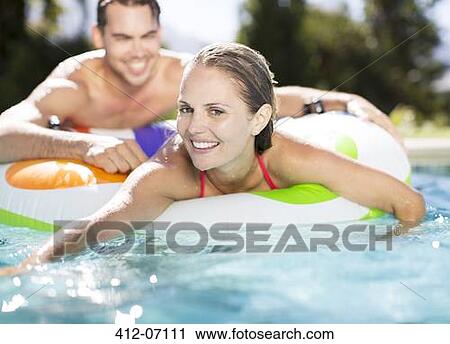 Couple relaxing in swimming pool View Large Photo Image Stock Image - Couple relaxing in swimming pool. Fotosearch