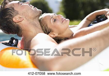 Couple relaxing in swimming pool View Large Photo Image Stock Photo - Couple relaxing in swimming pool. Fotosearch