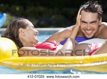 Stock Photography - Couple relaxing in swimming pool. Fotosearch