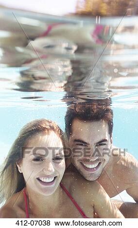 Stock Photo - Couple smiling in swimming pool. Fotosearch