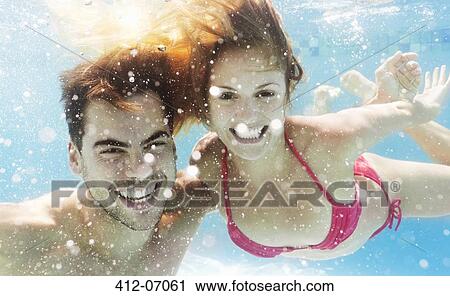 Couple swimming in pool View Large Photo Image Stock Image - Couple swimming in pool. Fotosearch
