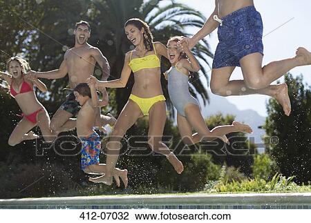Stock Image - Family jumping into swimming pool. Fotosearch
