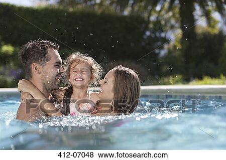 Stock Photo - Family playing in swimming pool. Fotosearch