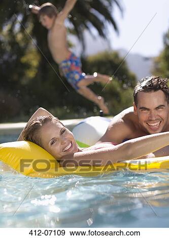 Family playing in swimming pool View Large Photo Image Stock Photo - Family playing in swimming pool. Fotosearch