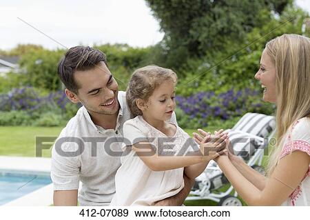 Stock Photo - Family playing together in backyard. Fotosearch