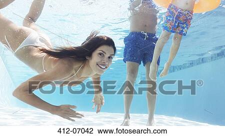 Stock Image - Family swimming in pool. Fotosearch