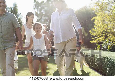 Family walking together in backyard View Large Photo Image Stock Image - Family walking together in backyard. Fotosearch