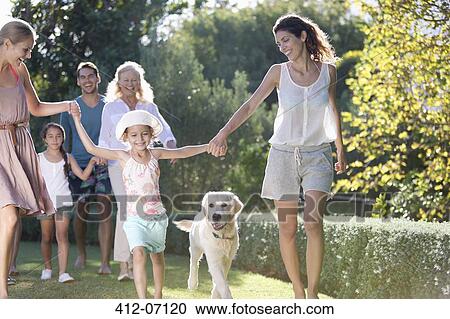 Stock Image - Family walking together in park. Fotosearch