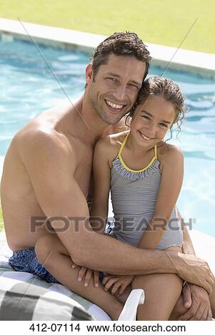Father and daughter sitting by swimming pool View Large Photo Image Picture - Father and daughter sitting by swimming pool. Fotosearch