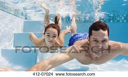 Picture - Father and daughter swimming in pool. Fotosearch
