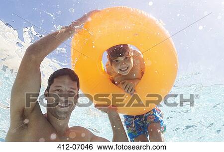 Father and son playing in swimming pool View Large Photo Image Stock Photograph - Father and son playing in swimming pool. Fotosearch