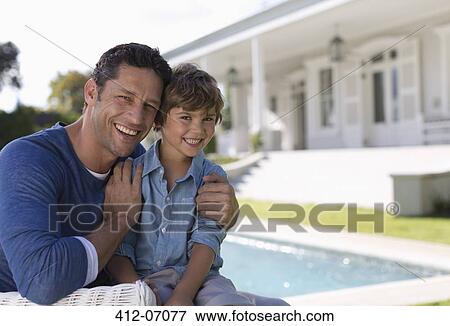 Stock Photo - Father and son smiling outside house. Fotosearch