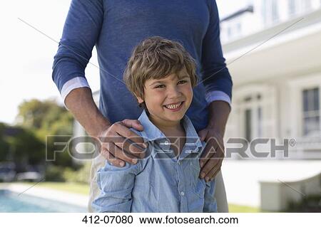 Stock Image - Father and son standing outdoors. Fotosearch