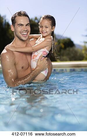Father holding daughter in swimming pool View Large Photo Image Stock Photograph - Father holding daughter in swimming pool. Fotosearch