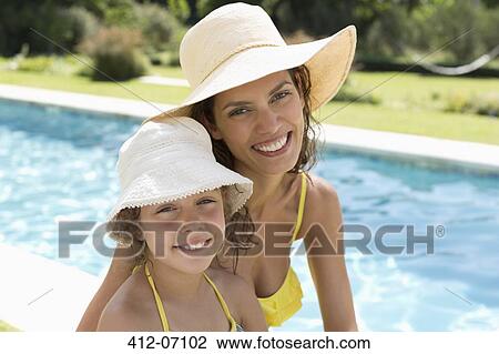 Mother and daughter relaxing by swimming pool View Large Photo Image Stock Image - Mother and daughter relaxing by swimming pool. Fotosearch