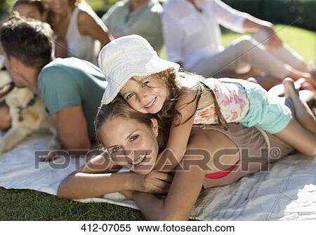 Mother and daughter relaxing in grass with family View Large Photo Image Stock Photography - Mother and daughter relaxing in grass with family. Fotosearch