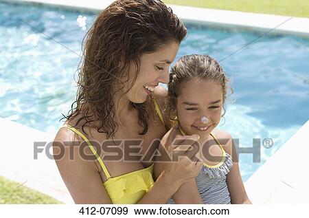 Mother applying sunscreen to daughter's nose View Large Photo Image Stock Photo - Mother applying sunscreen to daughter's nose. Fotosearch