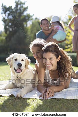 Mother, daughter and dog laying in grass View Large Photo Image Picture - Mother, daughter and dog laying in grass. Fotosearch