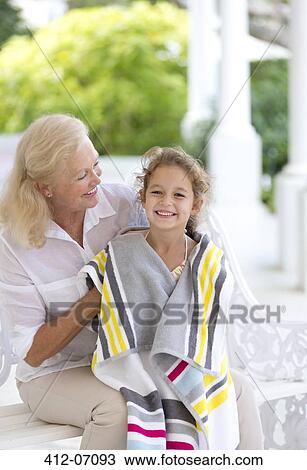 Stock Image - Woman wrapping granddaughter in towel. Fotosearch