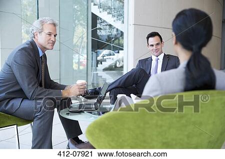 Stock Image - Business people meeting in lobby. Fotosearch