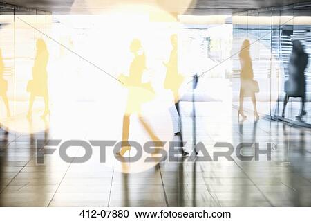 Stock Image - Business people walking in lobby. Fotosearch