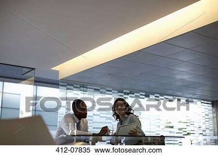 Businessman and businesswoman discussing paperwork View Large Photo Image Stock Photography - Businessman and businesswoman discussing paperwork. Fotosearch