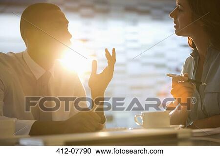 Stock Image - Businessman and businesswoman talking. Fotosearch