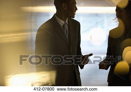 Businessman and businesswoman talking in lobby View Large Photo Image Stock Image - Businessman and businesswoman talking in lobby. Fotosearch