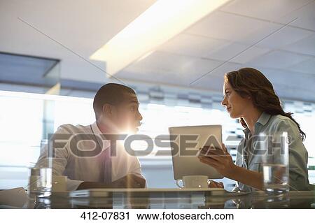 Stock Image - Businessman and businesswoman using digital tablet. Fotosearch