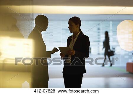 Businessman and businesswoman using digital tablet in lobby View Large Photo Image Stock Photo - Businessman and businesswoman using digital tablet in lobby. Fotosearch