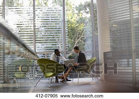 Businessman and businesswoman using laptop in lobby View Large Photo Image Stock Photography - Businessman and businesswoman using laptop in lobby. Fotosearch