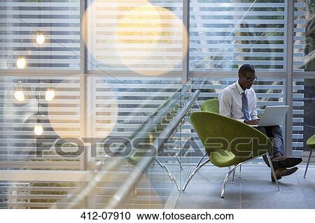 Businessman using laptop in lobby View Large Photo Image Stock Image - Businessman using laptop in lobby. Fotosearch